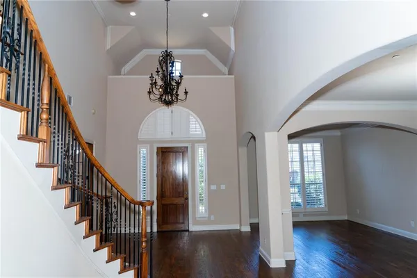 a view of a hallway with wooden floor and staircase