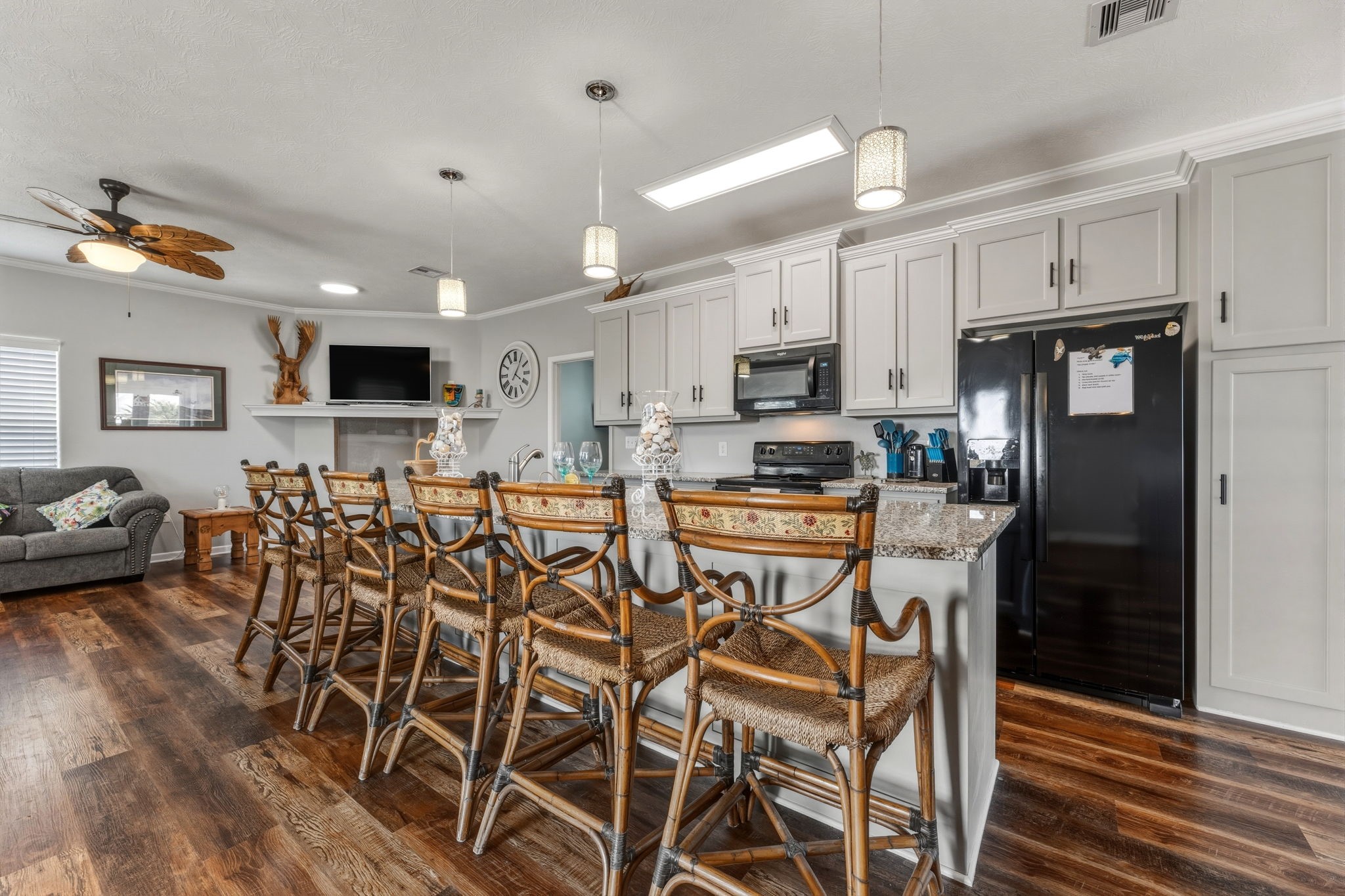 920 Palm View Crystal Beach, TX 77650 - Photo 11 of 26 a kitchen with stainless steel appliances granite countertop a stove top oven a refrigerator a sink a dining table and chairs with wooden floor