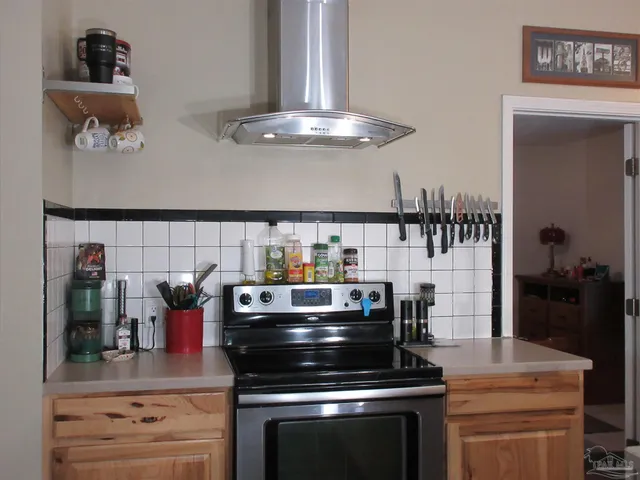 a kitchen with stainless steel appliances granite countertop a sink a refrigerator and a stove