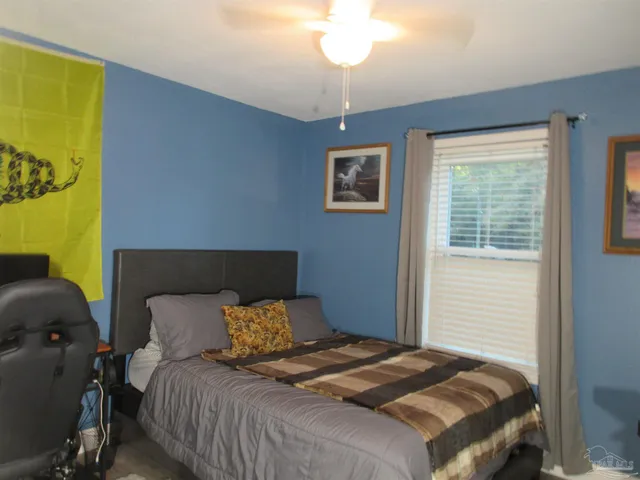 a bedroom with a bed and a lamp on dresser