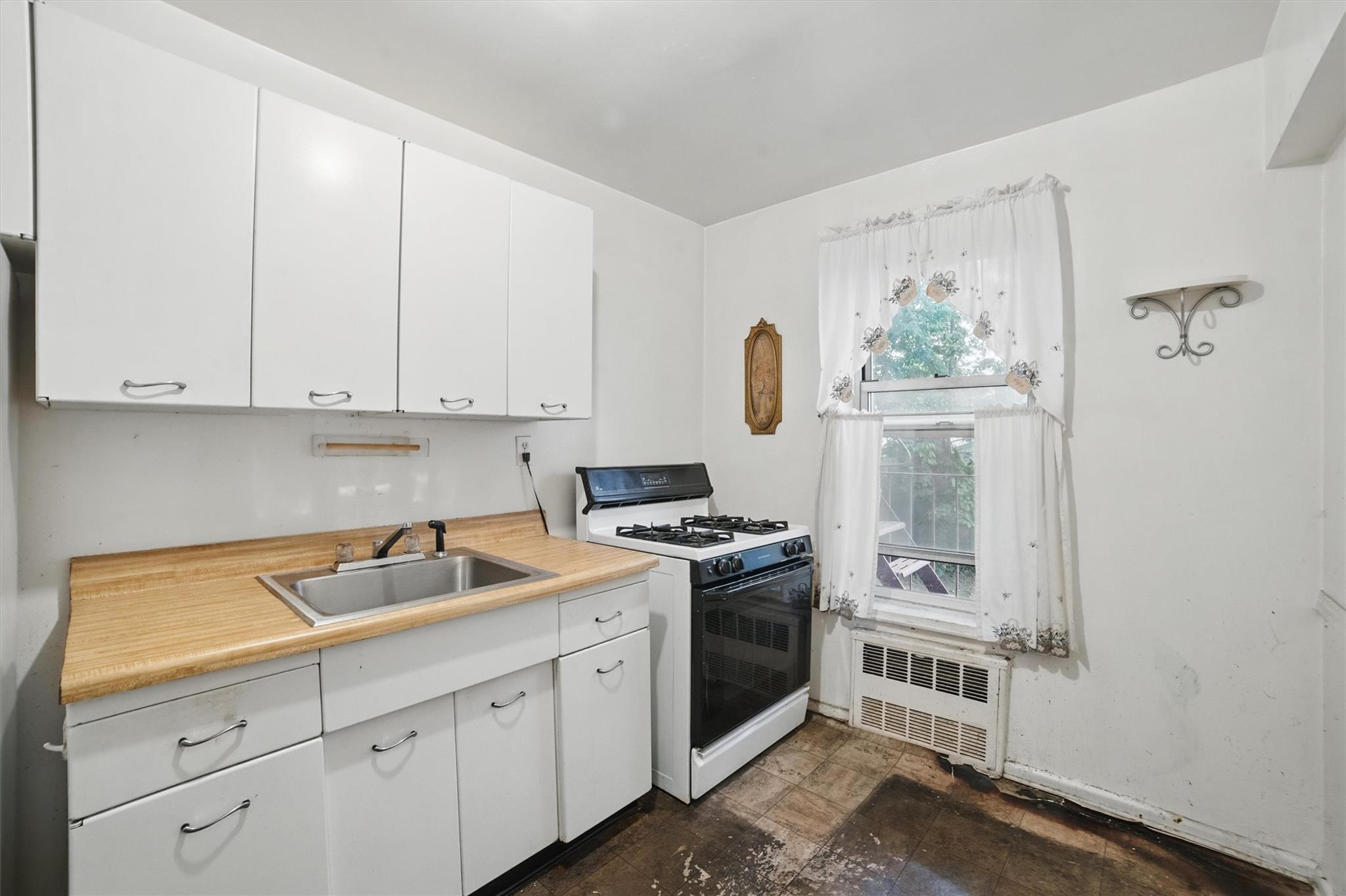 682 Tuckahoe Road, Unit 1A Yonkers, NY 10710 - Photo 11 of 17 a kitchen with white cabinets and white appliances