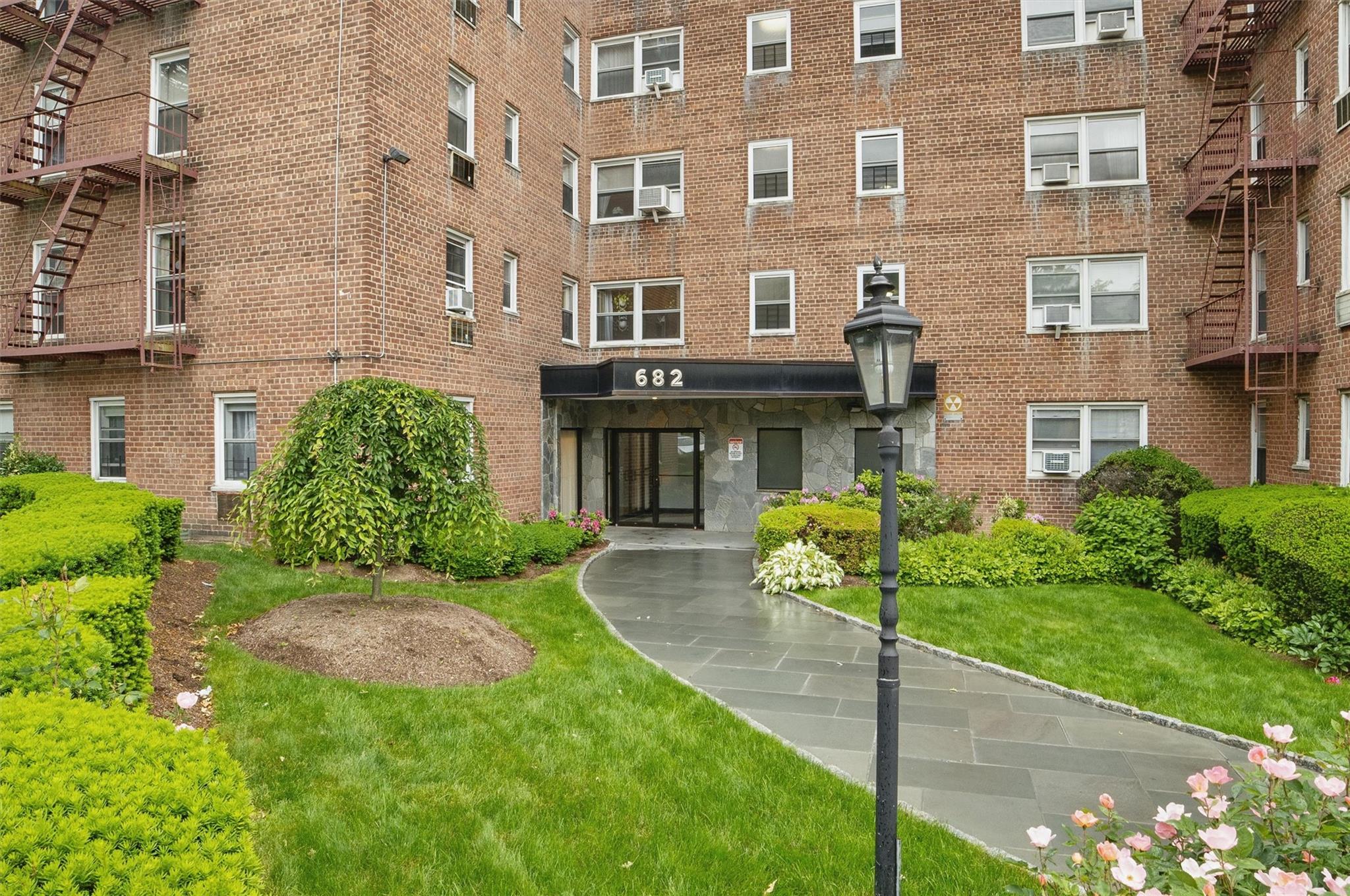 682 Tuckahoe Road, Unit 1A Yonkers, NY 10710 - Photo 2 of 17 a view of a brick building next to a yard