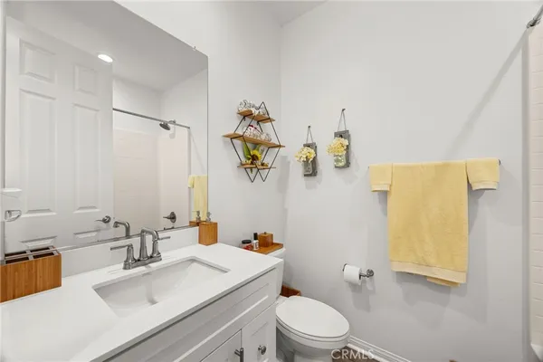a bathroom with a sink mirror vanity and toilet