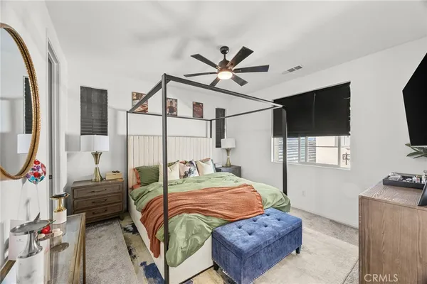 a bedroom with a bed a flat screen tv and dresser