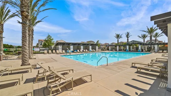 a view of a swimming pool with lawn chairs and a big yard