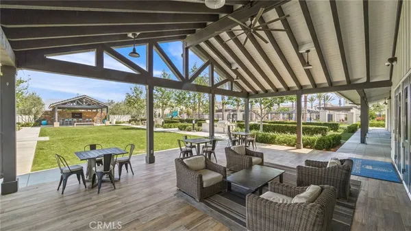 a view of a patio with couches chairs dining table and chairs under an umbrella