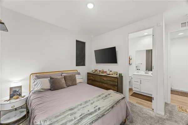 a bedroom with a bed and a flat screen tv