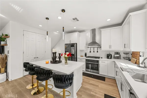 a kitchen with kitchen island a stove a table and chairs in it