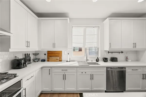 a kitchen with granite countertop a sink a stove and cabinets