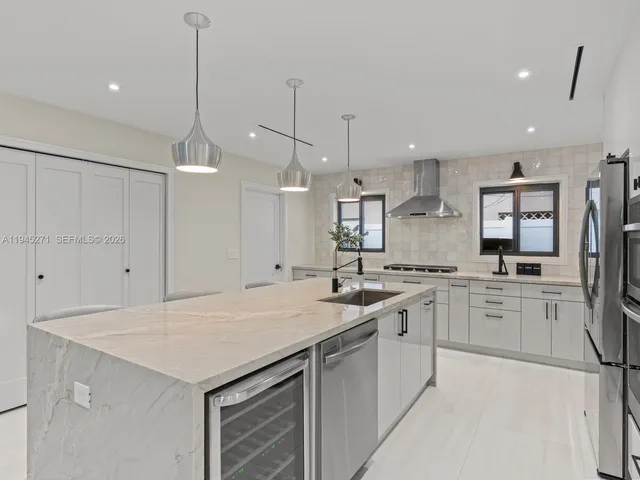 a kitchen with a sink a stove a refrigerator and white cabinets