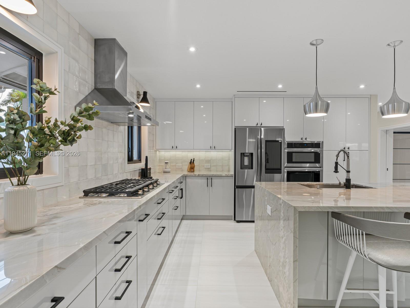 511 Southeast 14th Street, Unit 1 Pompano Beach, FL 33060 - Photo 12 of 20 a kitchen with stainless steel appliances kitchen island a stove a sink a refrigerator and a counter top space