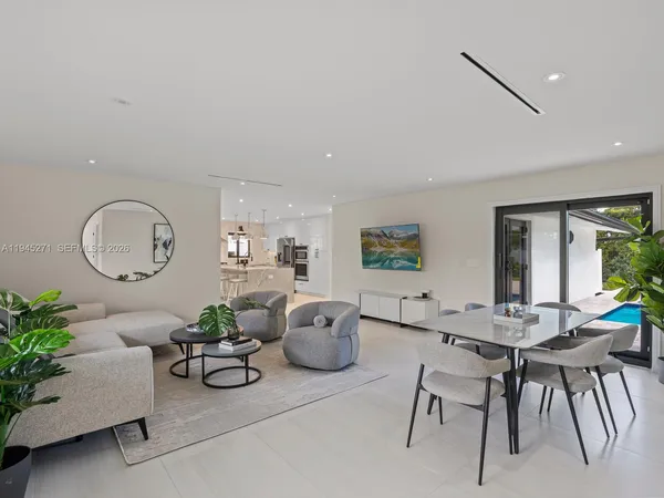 a living room with furniture potted plant and a large window