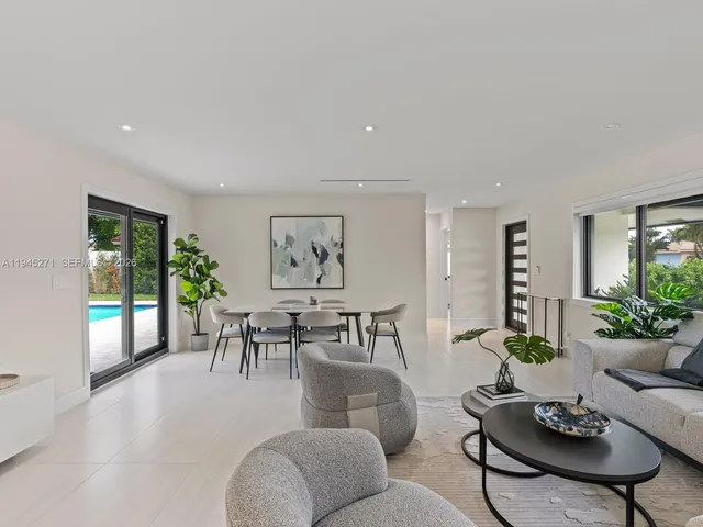 a living room with furniture potted plant and a large window