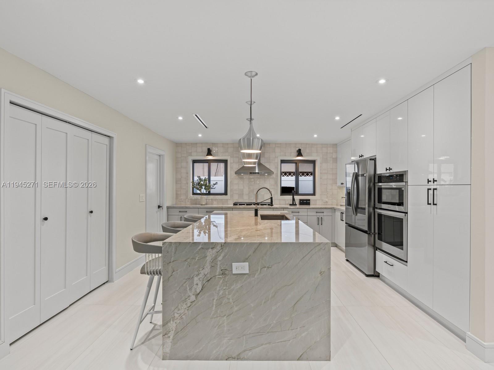 511 Southeast 14th Street, Unit 1 Pompano Beach, FL 33060 - Photo 9 of 20 a large white kitchen with a large window and stainless steel appliances