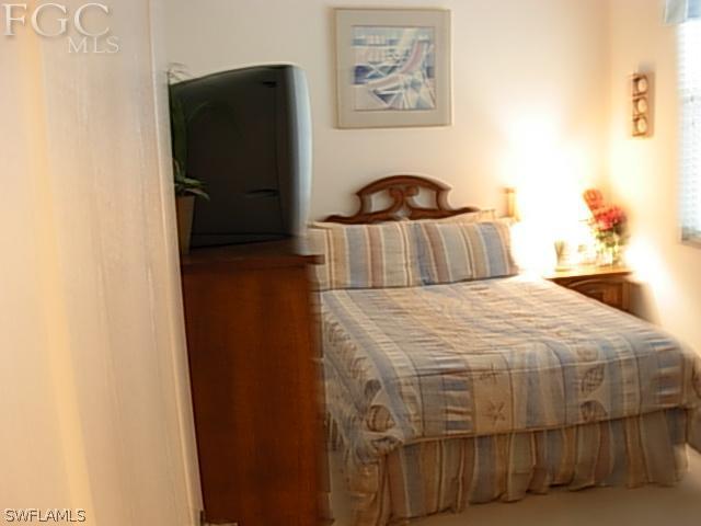 14081 Brant Point Circle, Unit 537 Fort Myers, FL 33919 - Photo 4 of 23 a bedroom with a bed and a painting on the wall