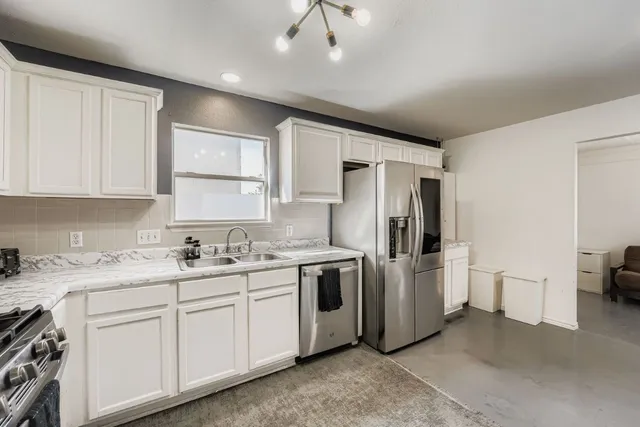 a kitchen with stainless steel appliances a refrigerator sink and cabinets