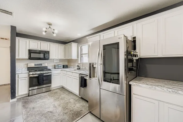 a kitchen with stainless steel appliances granite countertop a refrigerator stove and microwave
