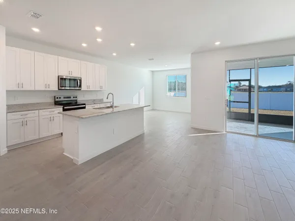 a kitchen with granite countertop a stove top oven and cabinets