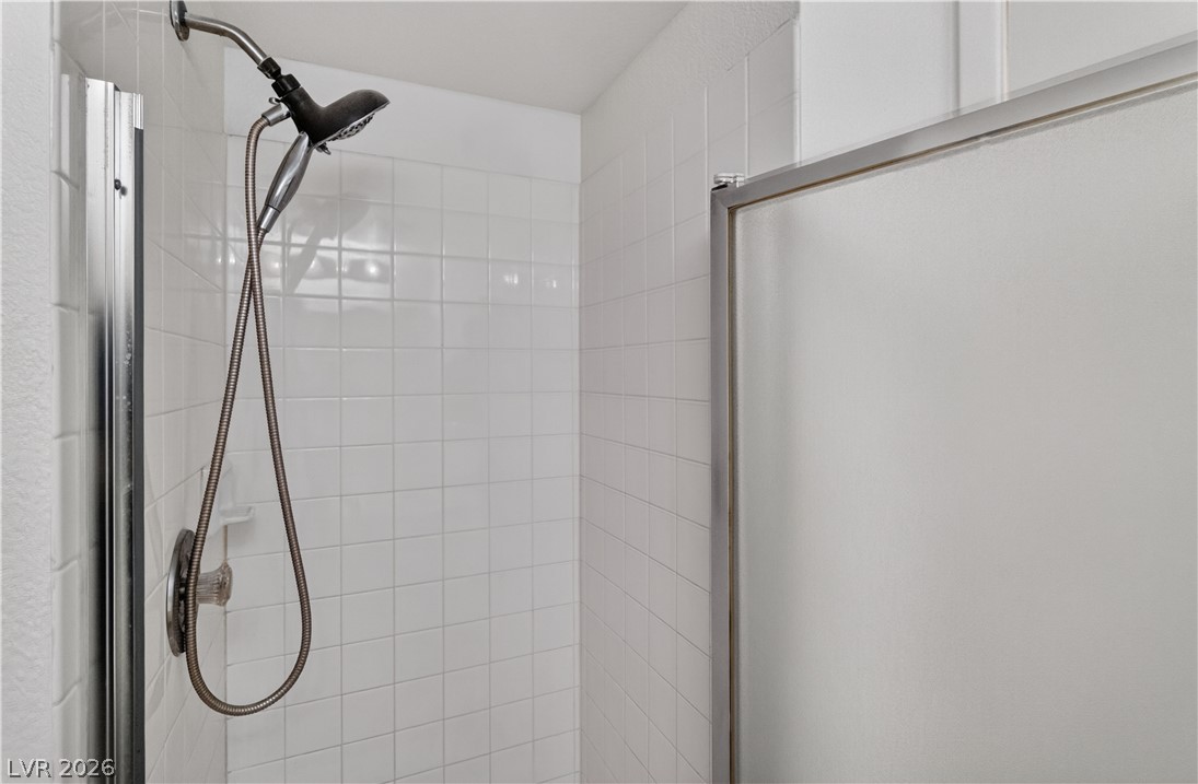 3156 Terrace View Drive Laughlin, NV 89029 - Photo 26 of 94 A well-maintained shower area, tiled in white, features a convenient handheld showerhead.