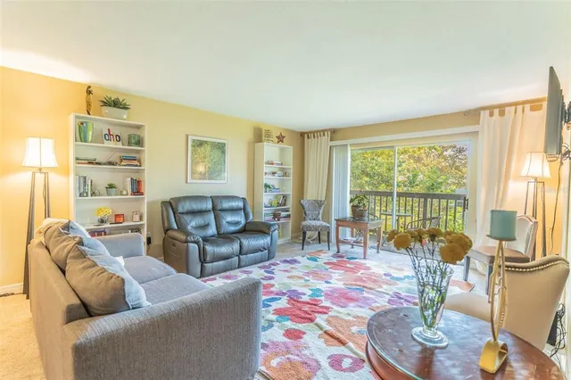 a living room with furniture and a floor to ceiling window