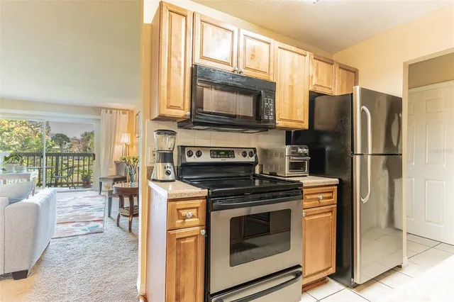 a kitchen with a stove a fridge and a couch