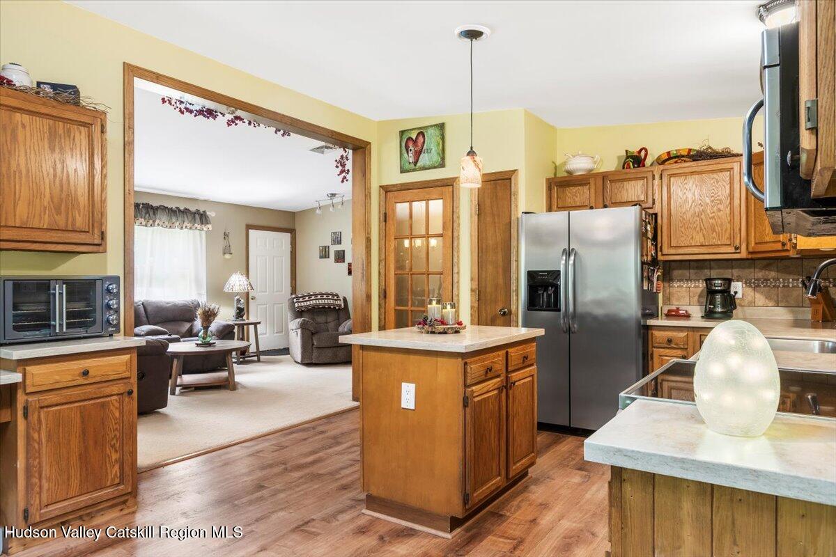 61 Travis Boulevard Catskill, NY 12414 - Photo 11 of 30 a kitchen with stainless steel appliances granite countertop a refrigerator a stove and a sink with wooden floor