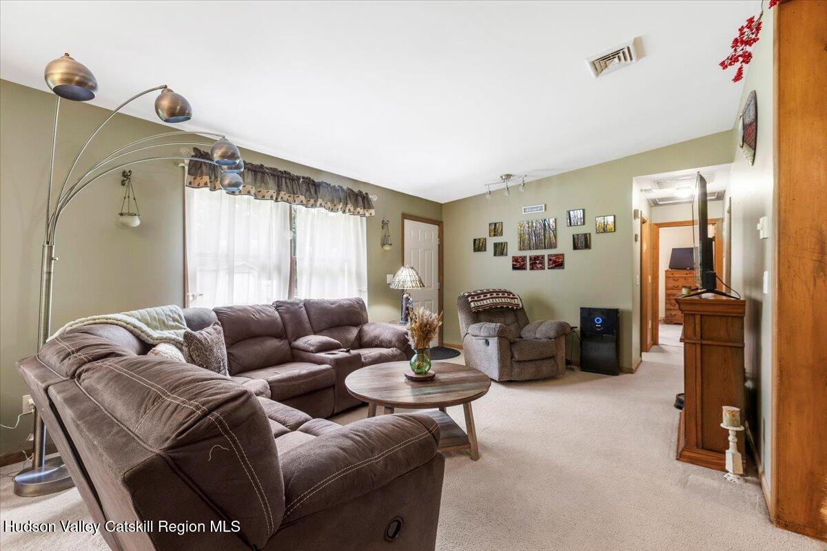61 Travis Boulevard Catskill, NY 12414 - Photo 15 of 30 a living room with furniture and a large mirror
