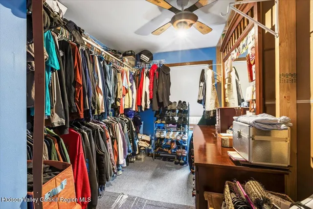 a view of walk in closet with clothes and shoes