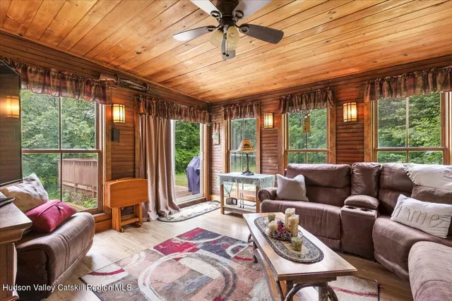 a living room with furniture and floor to ceiling windows