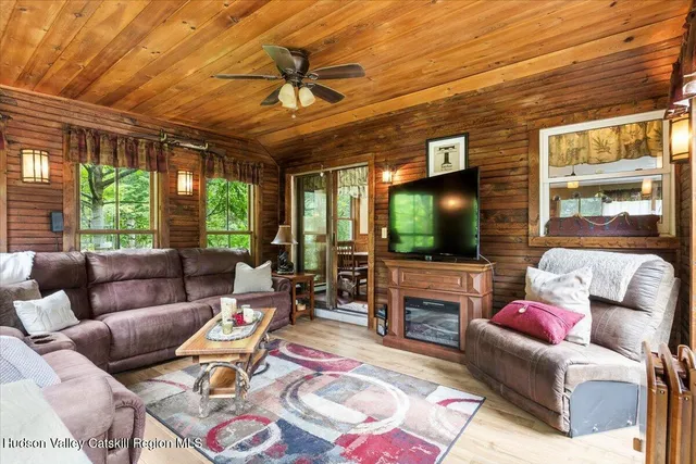 a living room with furniture a flat screen tv and a large window