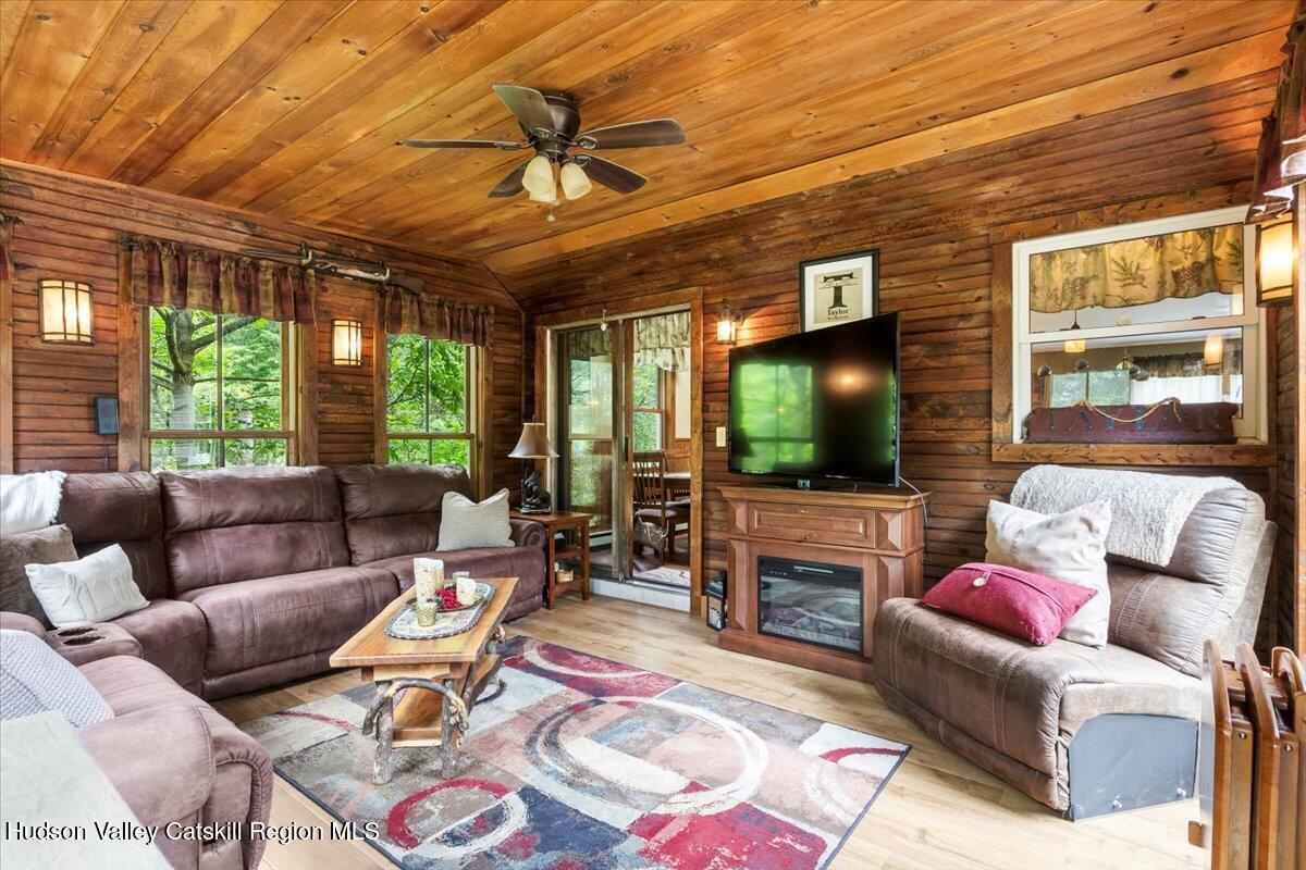 61 Travis Boulevard Catskill, NY 12414 - Photo 4 of 30 a living room with furniture a flat screen tv and a large window
