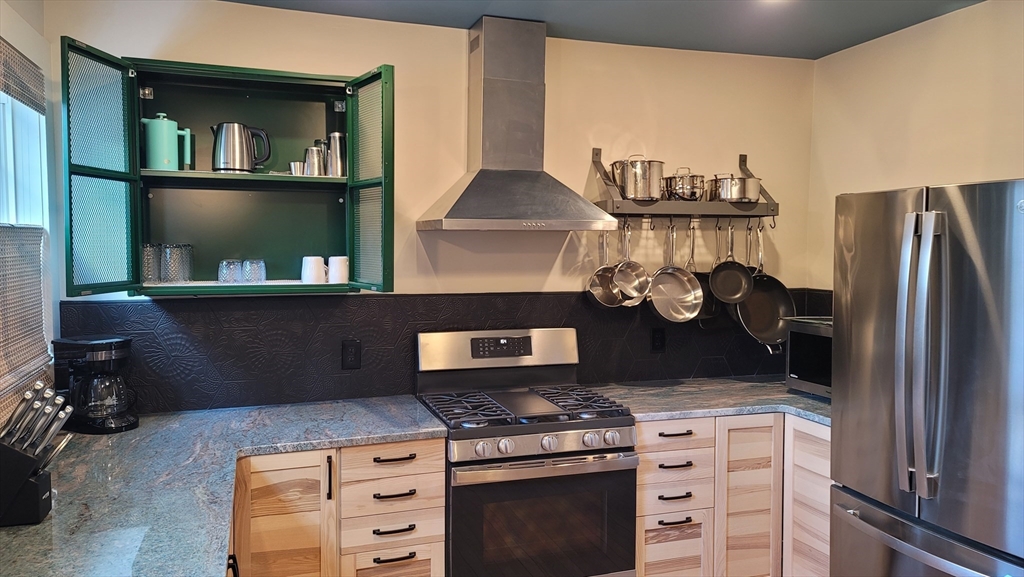 55 Buffum Street, Unit 2 Salem, MA 01970 - Photo 2 of 10 a kitchen with a stove and a cabinet with wooden floor