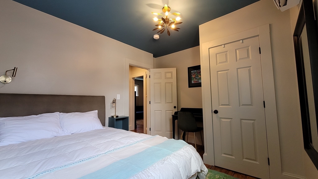 55 Buffum Street, Unit 2 Salem, MA 01970 - Photo 8 of 10 a bedroom with a bed and a chandelier