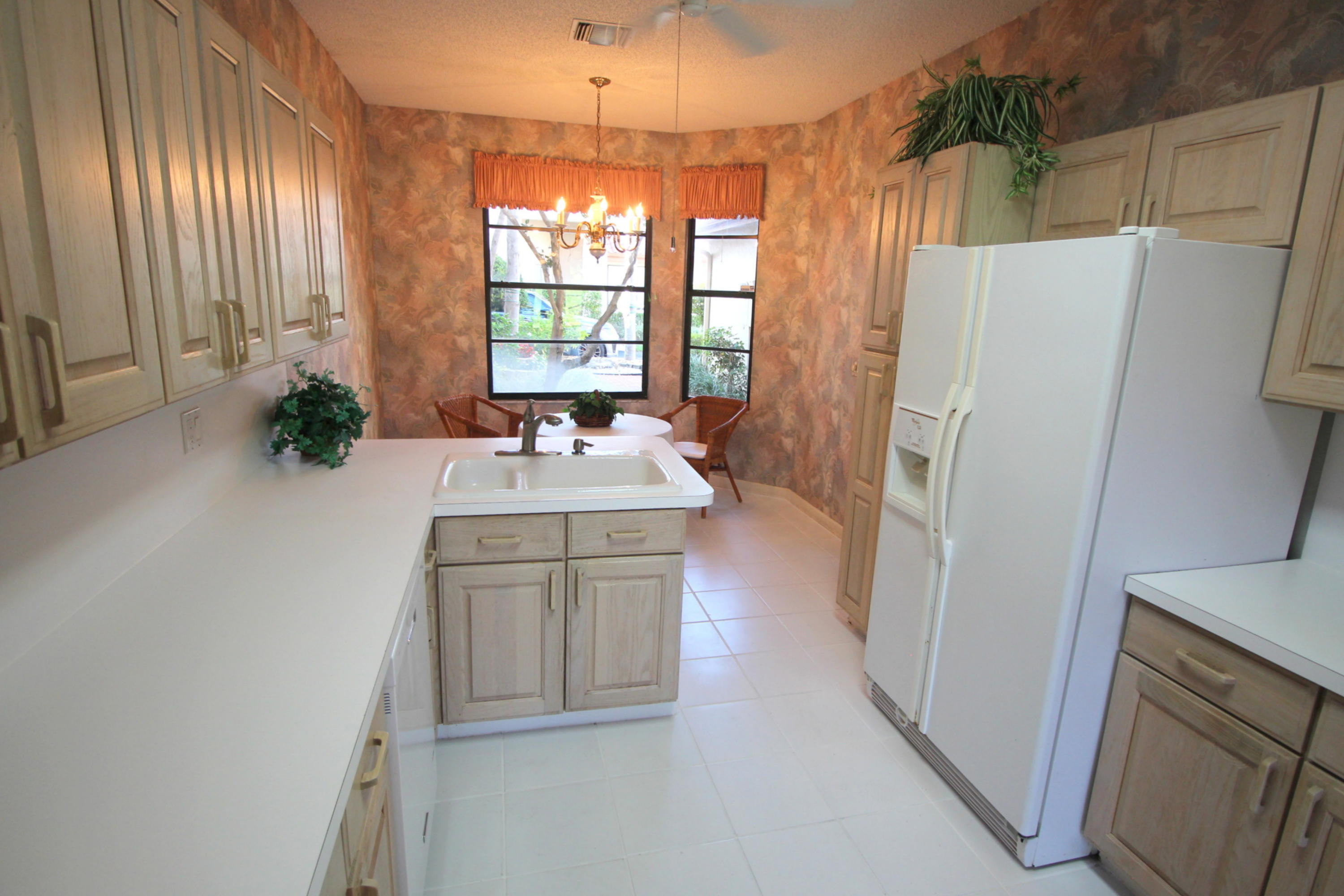 23475 Water Circle Boca Raton, FL 33486 - Photo 12 of 32 a kitchen with a refrigerator a sink and dishwasher with a large window