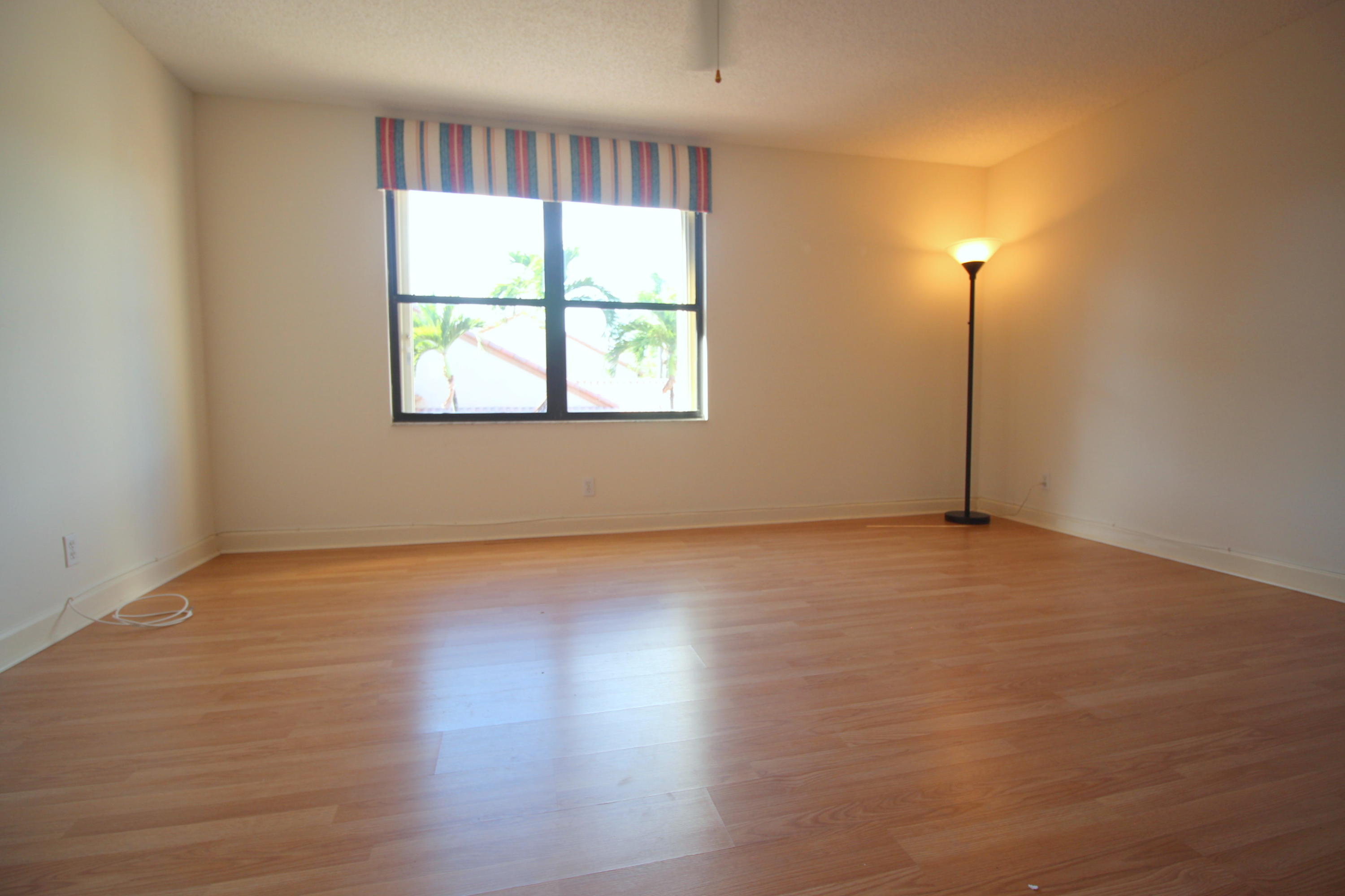 23475 Water Circle Boca Raton, FL 33486 - Photo 25 of 32 an empty room with wooden floor and windows