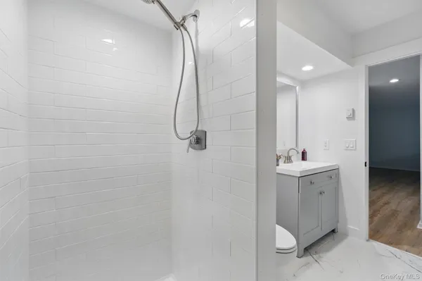 a bathroom with a granite countertop sink a toilet and shower