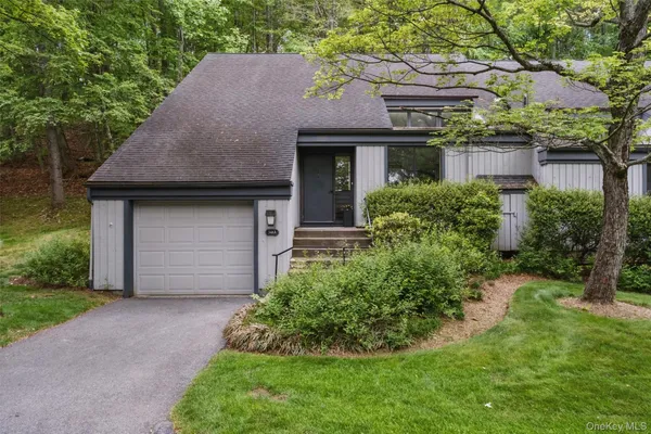 a front view of a house with a garden and plants
