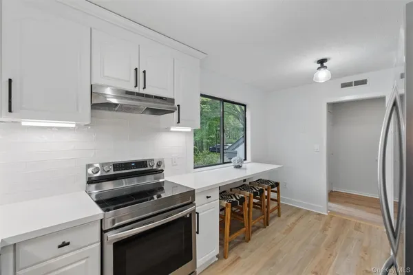 a kitchen with stainless steel appliances a stove a sink and a refrigerator