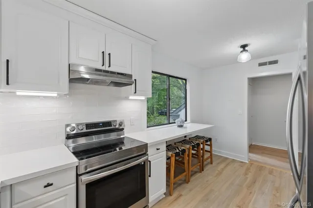 a kitchen with stainless steel appliances a stove a sink and a refrigerator