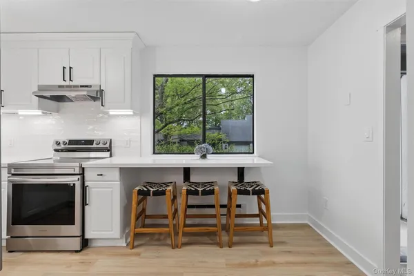 a kitchen with stainless steel appliances a stove a refrigerator and a window