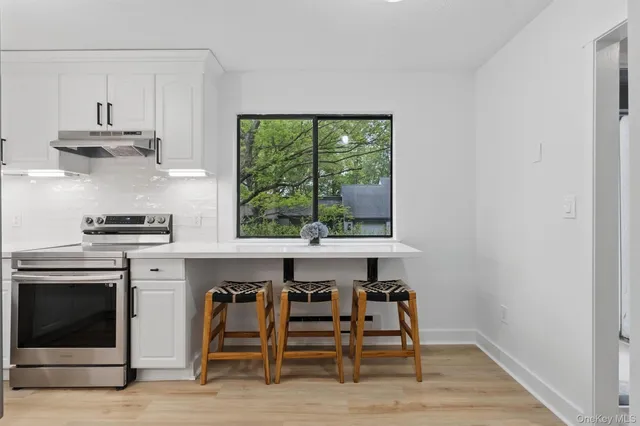 a kitchen with stainless steel appliances a stove a refrigerator and a window