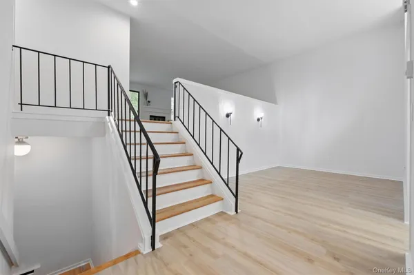 a view of a hallway with wooden floor and stairs