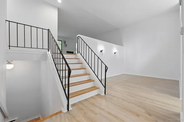 a view of a hallway with wooden floor and stairs