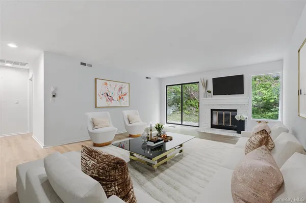 a living room with furniture a fireplace and a large window