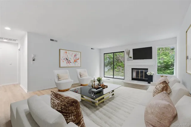 a living room with furniture a fireplace and a large window