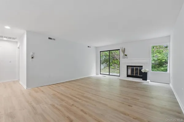a view of an empty room with a window and fireplace
