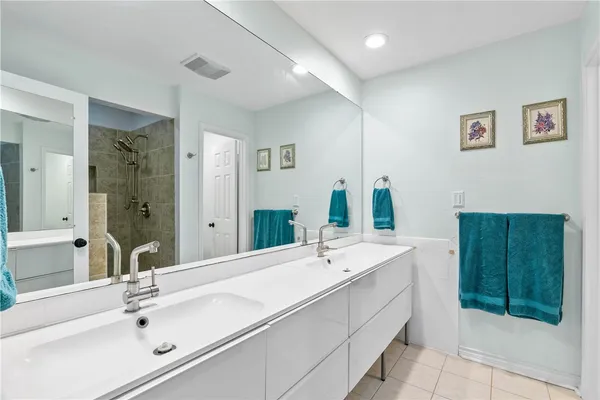 a bathroom with a double vanity sink mirror and shower