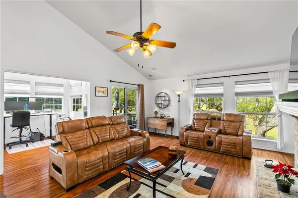 a living room with furniture a fireplace and a large window