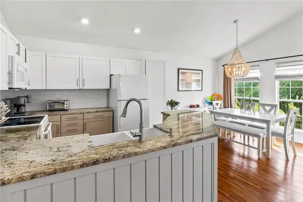 a kitchen with granite countertop a sink a counter top space and cabinets