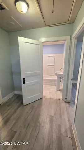 a view of a room with wooden floor and white walls